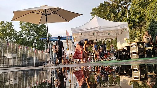 Stand des Labyrinth Kulturcafés spiegeln sich in einer Pfütze beim FSJ in Stuttgart