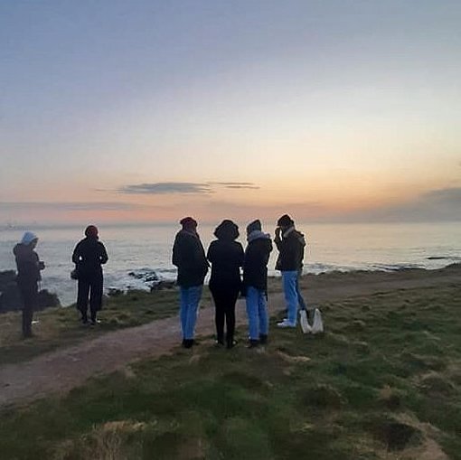 Freiwillige bei Sonnenuntergang vor dem Meer beim FSJ in Großbritannien