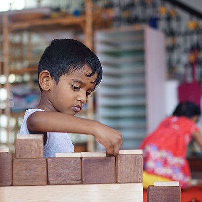 Kind spielt mit Bauklötzen beim FSJ Indien