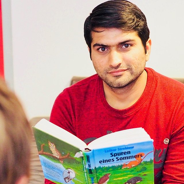 Incoming Freiwilliger liest aus einem Buch vor beim FSJ Schule