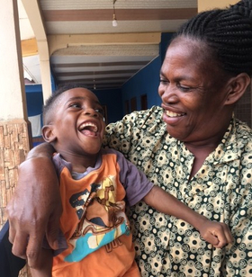 Curative education Ghana A woman holds a laughing child in her arms