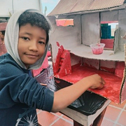 Kind bastelt ein Haus aus Pappe im Rahmen von Notfallpädagogik in Kolumbien