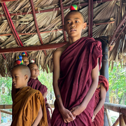 Notfallpädagogik Myanmar Kinder in roter Mönchskleidung balancieren kleine bunte Bälle auf dem Kopf