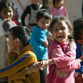 Jubiläum Notfallpädagogik Kinder halten sich an der Hand und lachen