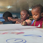 Notfallpädagogik Kenia Drei Kinder malen am Tisch