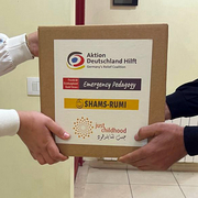 Libanon Notfallhilfe Hände halten Kiste mit Logos
